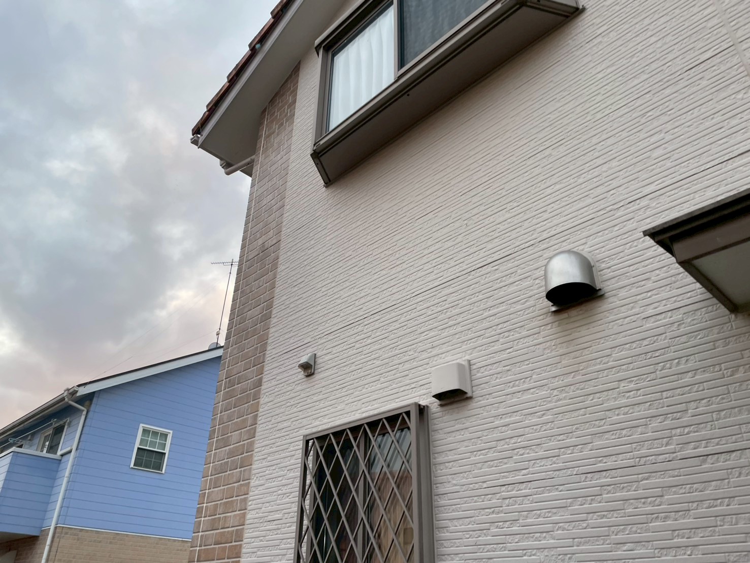 白い外壁が反り段差が発生している